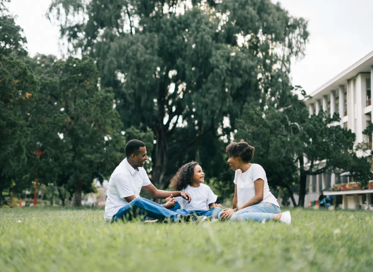 A family sitting together on the grass, smiling